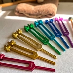 tarifs soins - photo des diapasons colorés des chakras utilisés pour le rééquilibrage énergétique, avec les couleurs associées aux chakras