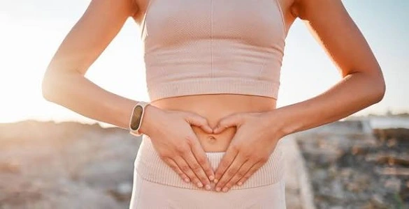 Photo d'une femme qui met les mains autour de son nombril, pour montrer que son chakra sacré est préservé